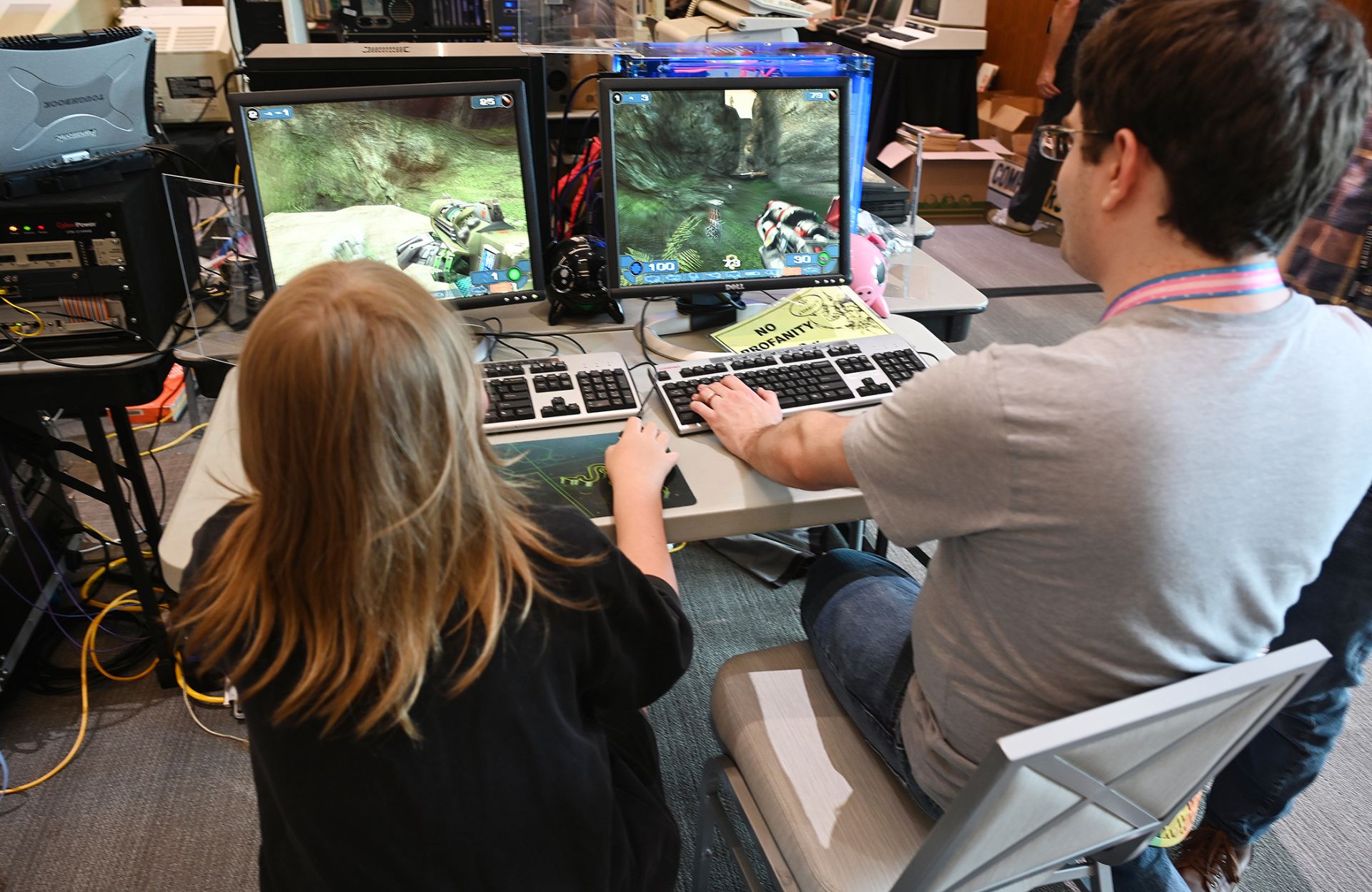 Two people playing a game on a vintage computer.
