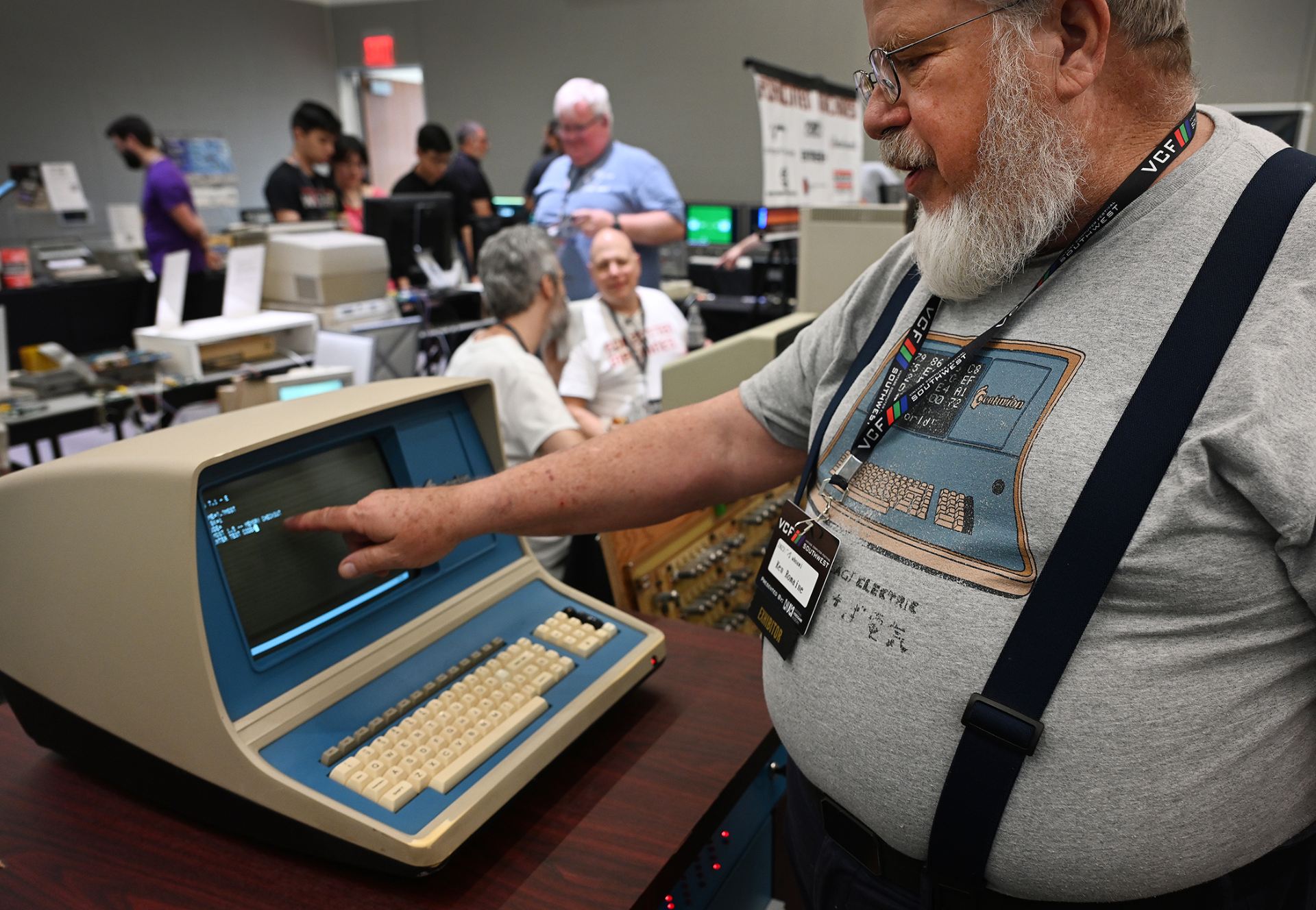 Man pointing on the screen of a vintage computer.